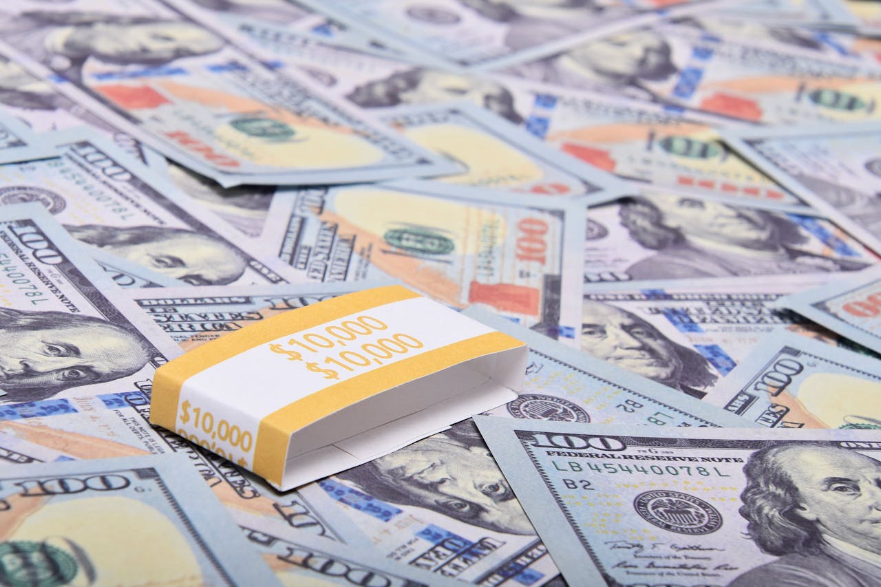 A stack of $100 bills arranged on a surface with US dollar notes. Ideal for finance themes.
